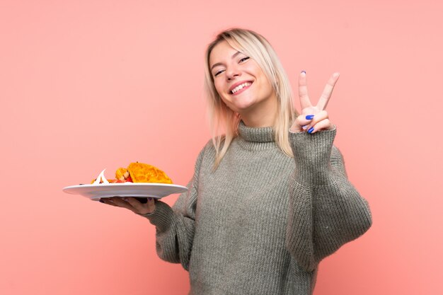 Uśmiechnięta osoba z talerzem jedzenia